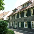Traditionelles Wohnhaus in Fachwerkstil mit Schieferfassade und grünen Fensterläden.