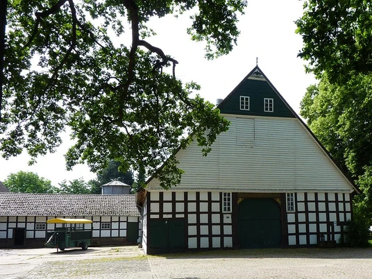 Sattelmeierhof Ebmeyer Historischer Fachwerkhof mit großem Satteldach, umgeben von alten Bäumen und ländlicher Ruhe.