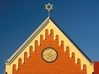 Synagoge Herford Backsteinfassade der Synagoge Herford mit Rosettenfenster und Davidstern auf dem Dach sichtbar.