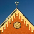 Synagoge Herford Backsteinfassade der Synagoge Herford mit Rosettenfenster und Davidstern auf dem Dach sichtbar.