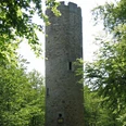 Nonnenstein Ein steinerner Aussichtsturm erhebt sich inmitten eines dichten, grünen Waldes unter sonnigem Himmel.