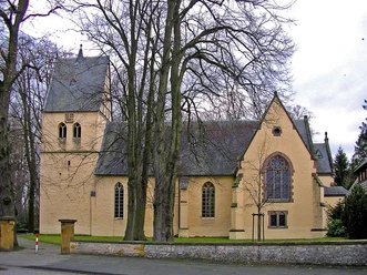 Historische Marienkirche Wallenbrück mit gelblicher Fassade, gotischen Fenstern und angrenzendem Turm.