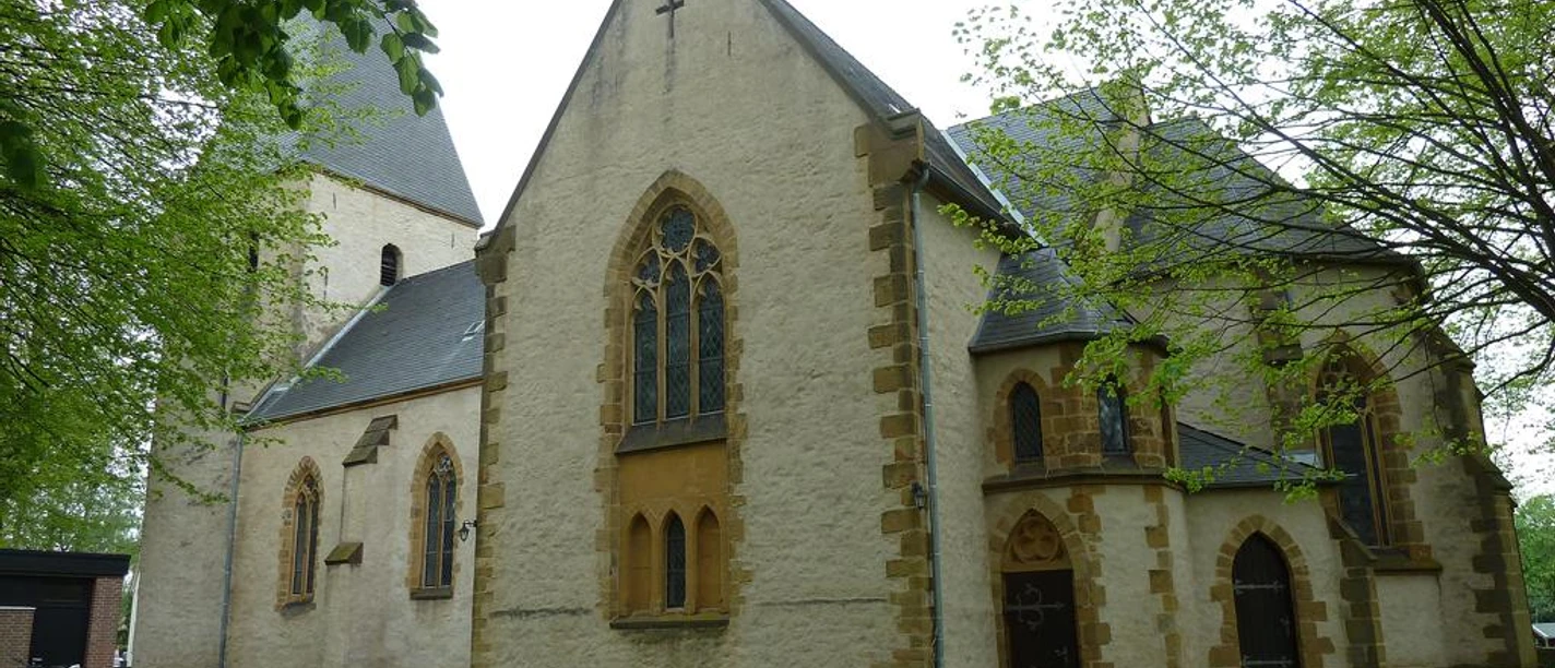 St.-Martins-Kirche St.-Martins-Kirche mit gotischem Spitzfenster, umgeben von grünem Laub und einem gepflegten Rasen.