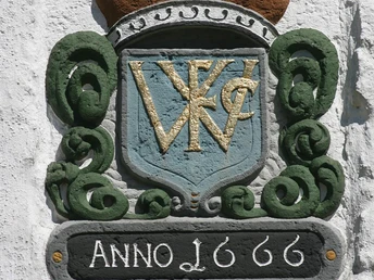 Wappenstein mit goldenen Buchstaben "VWC", umgeben von grünen Ornamenten, darunter Jahreszahl 1666.