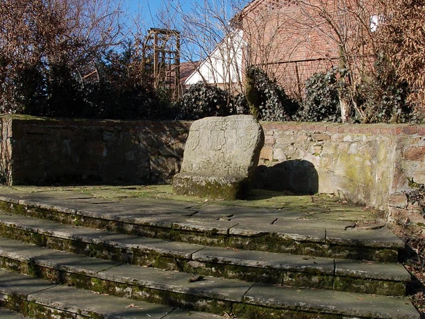 Der Wittekindstein, ein bedeutendes Denkmal, liegt eingebettet in eine historische Steinmauer.