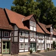 Fachwerkhäuser mit roten Ziegeldächern reihen sich entlang einer gepflasterten Straße in Lügde.
