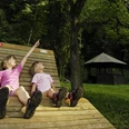 Das Kombiskop befindet sich direkt an einer Schutzhütte und Liegebank Zwei Kinder sitzen auf der Liegebank im Arboretum Bad Driburg.