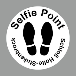 Selfie-Point SHS Schablone Kreisförmiges Schild mit der Aufschrift "Selfie Point Schloss Holte-Stukenbrock", darunter Fußabdrücke.