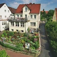 Gästehaus Havergoh Gästehaus Havergoh mit gepflegtem Garten und Balkon, umgeben von weiteren Wohnhäusern.