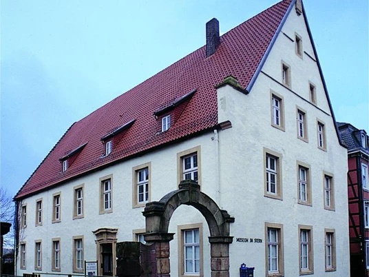 Museum im "Stern Historisches Gebäude mit rotem Dach und steinernem Torbogen, das Museum im "Stern" beherbergt.