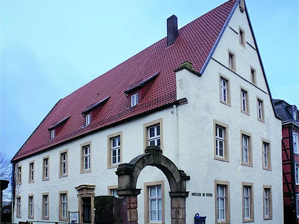 Museum im "Stern Historisches Gebäude mit rotem Dach und steinernem Torbogen, das Museum im "Stern" beherbergt.