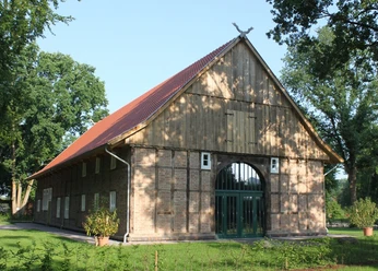 Bürgerhaus Marienfeld Historisches Fachwerkhaus mit Backsteinmauern und rotem Satteldach, von Bäumen umgeben.