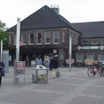 Bahnhof Rheine Backsteingebäude des Rheiner Bahnhofs mit Passanten und geparkten Fahrrädern vor dem Eingang.