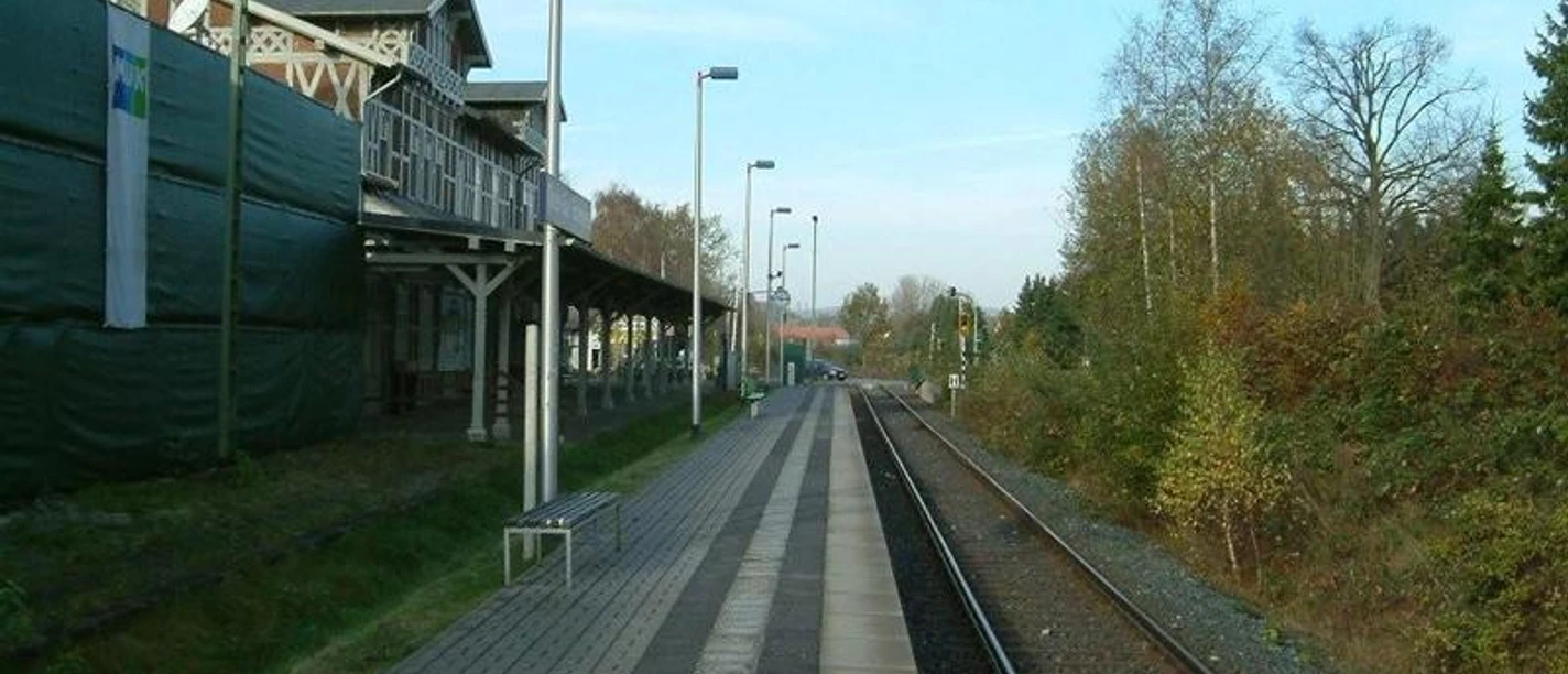 Bahnhof Dissen Historischer Bahnhof Dissen mit Gleisen, Bahnsteig, umgeben von Herbstbäumen unter klarem Himmel.