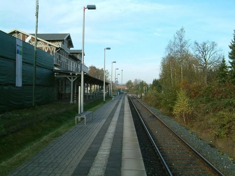 Bahnhof Dissen Historischer Bahnhof Dissen mit Gleisen, Bahnsteig, umgeben von Herbstbäumen unter klarem Himmel.