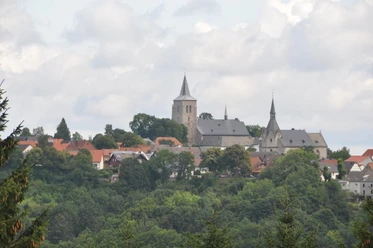 Blick nach Obermarsberg auf die Stiftskirche und die Nikolaikirche Blick auf Obermarsberg mit der markanten Stiftskirche und Nikolaikirche umgeben von grüner Landschaft.