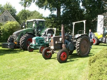 Aktionstag 2009 Drei historische Traktormodelle auf einer grünen Wiese bei einer mechanischen Ausstellung im Freien.