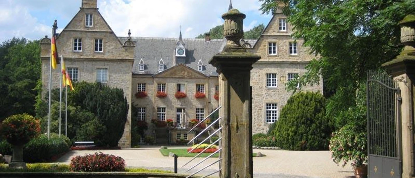 Wasserschloss Surenburg Historisches Wasserschloss Surenburg umgeben von Gärten, mit steinernem Tor und verzierter Fassade.