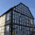 Fachwerkhaus in Bad Salzuflen, Nordrhein-Westfalen, bei Sonnenschein. Symmetrische Fassade mit weißen Wänden.