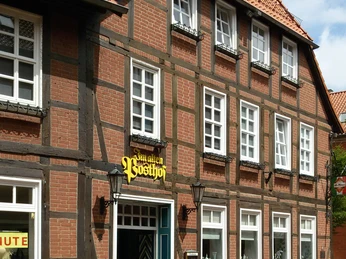 Alter Posthof Außenansicht Fachwerkgebäude mit traditioneller Backsteinfassade und roten Ziegeln in einer ruhigen Straße.