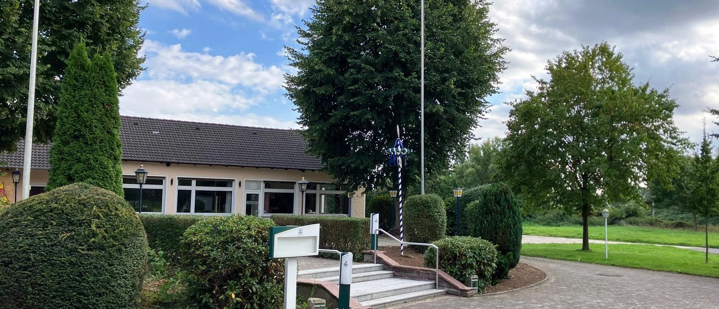 Mark's Restaurant mit Treppenaufgang, gepflegten Hecken und großen Bäumen am Vorplatz