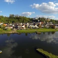 Blick auf Herstelle Luftbild von Herstelle: Malerische Häuser nahe der Weser, von Hügeln und Wäldern umgeben.