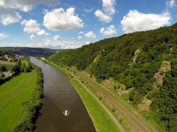 Hannoversche Klippen links Herstelle Luftaufnahme der Weser mit Boot, grünen Feldern und bewaldeten Hannoverschen Klippen bei Herstelle.
