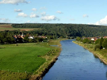 Herstelle rechts Würgassen links, Blick von der Weserbrücke Blick von der Weserbrücke über die Weser, umrahmt von Grünflächen und bewaldeten Hügeln.