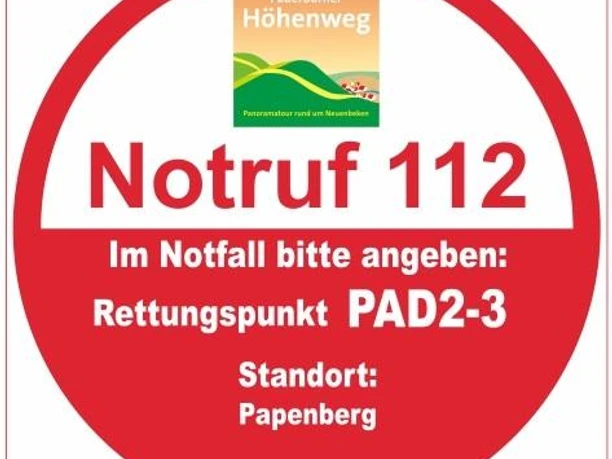 Rotes, rundes Rettungspunkt-Schild PAD2-3 am Papenberg, Notrufnummer 112, hilfreiche Notfallangabe.