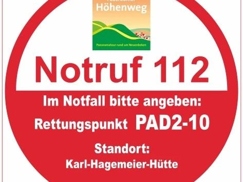 Runder Notfallschild des Paderborner Höhenwegs mit Angaben zu Rettungspunkt PAD2-10 bei der Karl-Hagemeier-Hütte.