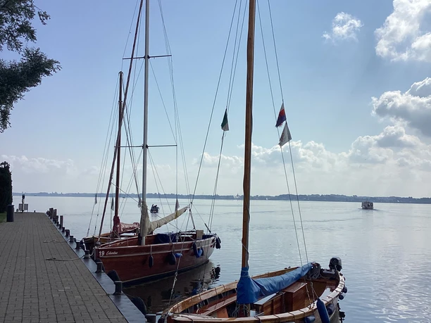 Insel Wilhelmstein Anleger Two sailing boats are moored on the calm Steinhuder Meer, under a clear summer sky.