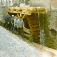 alte Mühle in Elbrinxen Fünf Männer posieren vor einem historischen Wasserrad an einer steinernen Mühle in Elbrinxen.