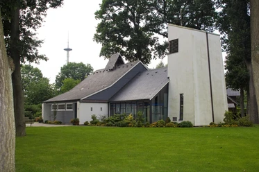 Evangelisch-lutherische St. Lukas Kirche Moderne Kirche mit schrägem Dach und hellem Turm, umgeben von Rasen und alten Bäumen in Werlte