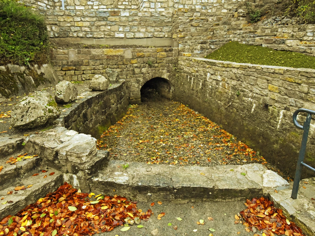 Nethequelle Neuenheerse Nethequelle in Neuenheerse: Historisches Quellbecken mit Herbstlaub, umgeben von Bruchsteinmauern.
