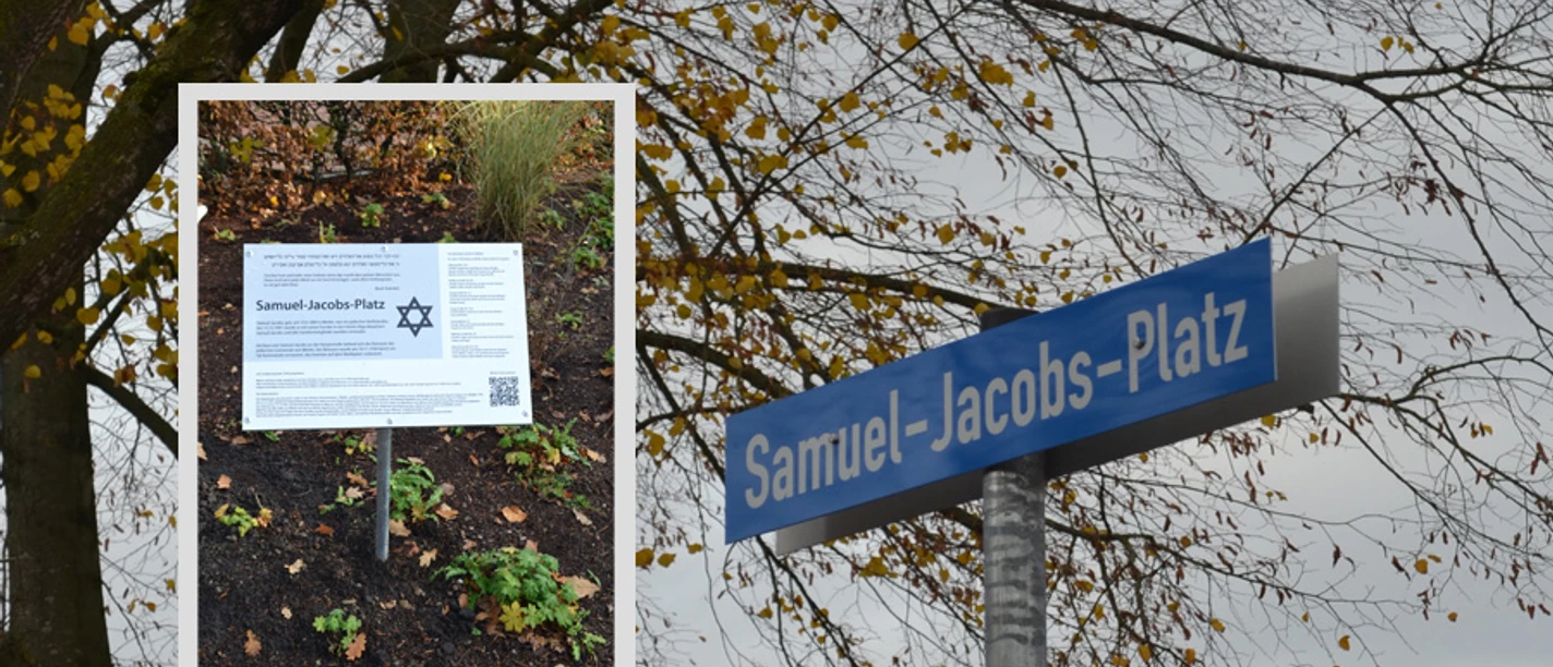 Samuel-Jacobs-Platz Blaues Straßenschild und Gedenktafel des Samuel-Jacobs-Platzes zwischen herbstlichen Bäumen.