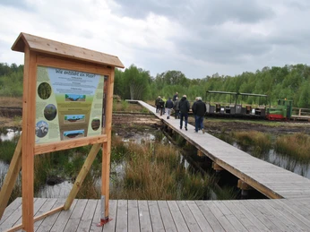 Hinweistafel am Ausstieg am Bohlenweg bei der Fahrt mit der Moorbahn in das Große Moor Westerbeck Gäste der Moorbahnfahrt am Ausstieg am Bohlenweg