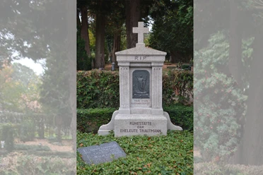 Grabstätte Albert Trautmann Steinerne Grabstätte der Eheleute Trautmann mit Kreuz und Christusrelief auf ruhigem Friedhof.