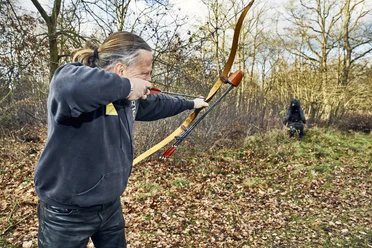 Bogenschießen im Parcours Bogensportler schießt auf eine Attrappe auf dem Bogensportparcours