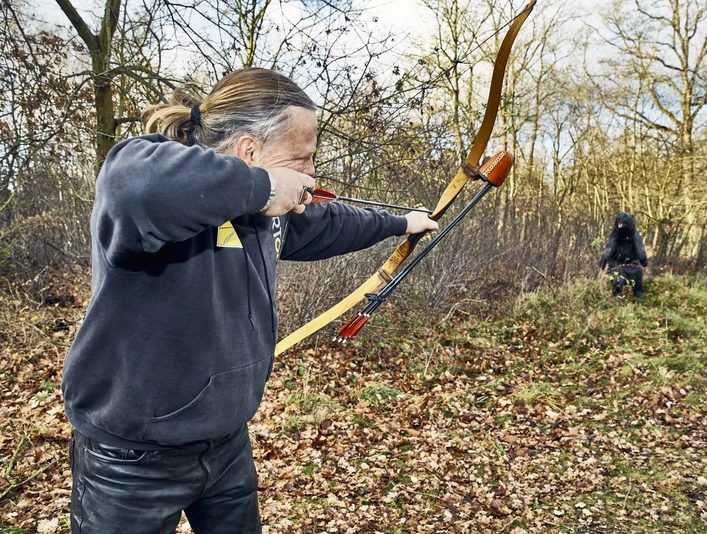 Bogenschießen im Parcours Bogensportler schießt auf eine Attrappe auf dem Bogensportparcours
