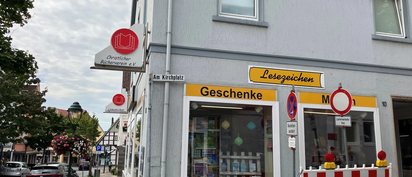 Fassade der Buchhandlung Lesezeichen mit gelben Schildern und Schaufenstern.