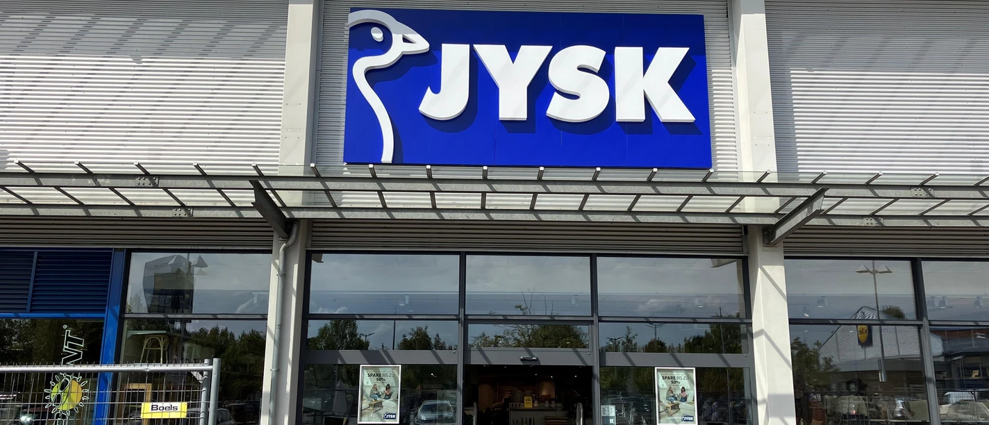 JYSK-Filiale mit blauem Logo über dem Eingang und Glasfront bei Tageslicht