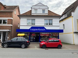 Schuhhaus Lappenbusch mit blauer Ladenfront, Schaufenstern und parkenden Autos davor