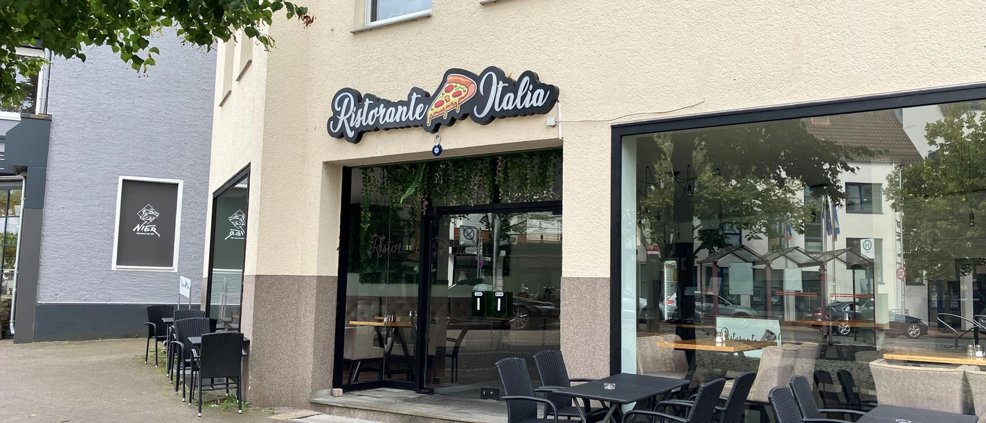 Außenansicht des Ristorante Italia mit Terrasse, großen Fenstern und Pizza-Logo