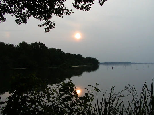 Abendstimmung am Hagenburger Kanal Sonnenuntergang spiegelt sich im ruhigen Wasser des Hagenburger Kanals, umringt von Bäumen.
