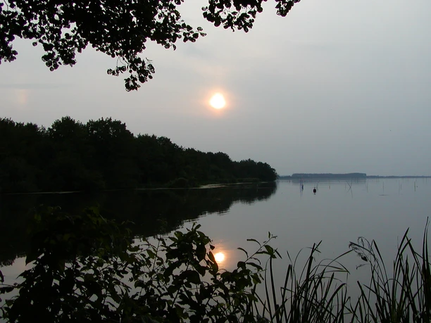 Abendstimmung am Hagenburger Kanal Sonnenuntergang spiegelt sich im ruhigen Wasser des Hagenburger Kanals, umringt von Bäumen.