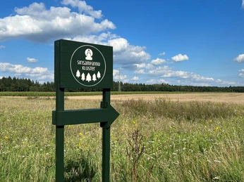 Kloster-Sirisampanno.jpg Wegweiser mit Klostersymbol weist auf das Kloster Sirisampanno, umgeben von einem weiten Feld.