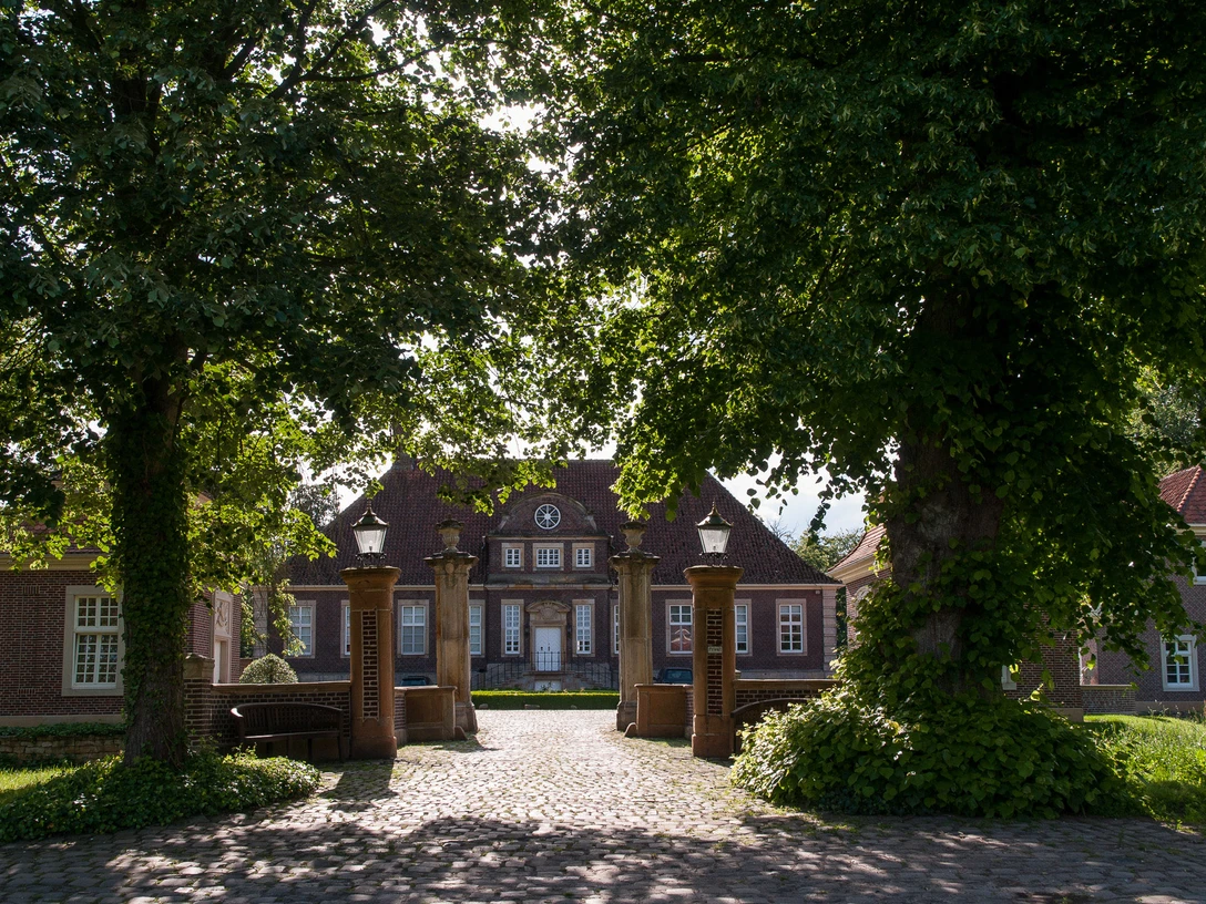 Schloss Herzford Backsteinernes Herrenhaus mit Toranlagen und altem Baumbestand im Sonnenschein von Lingen.