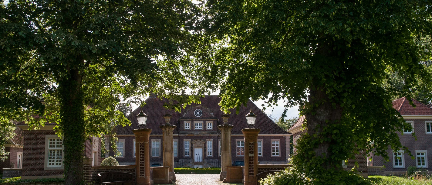 Schloss Herzford Backsteinernes Herrenhaus mit Toranlagen und altem Baumbestand im Sonnenschein von Lingen.