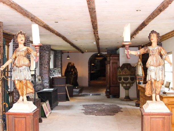 Alte Drostei Papenburg Innenraum der Alten Drostei Papenburg mit historischen Holzfiguren, Möbeln und Kirchenkunst.