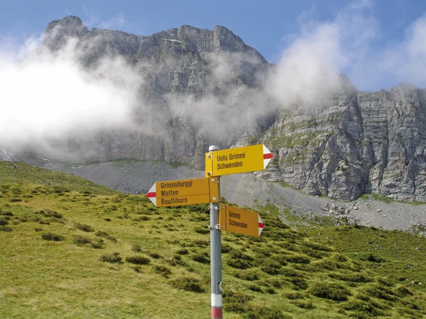 Wegweiser vor Felswand